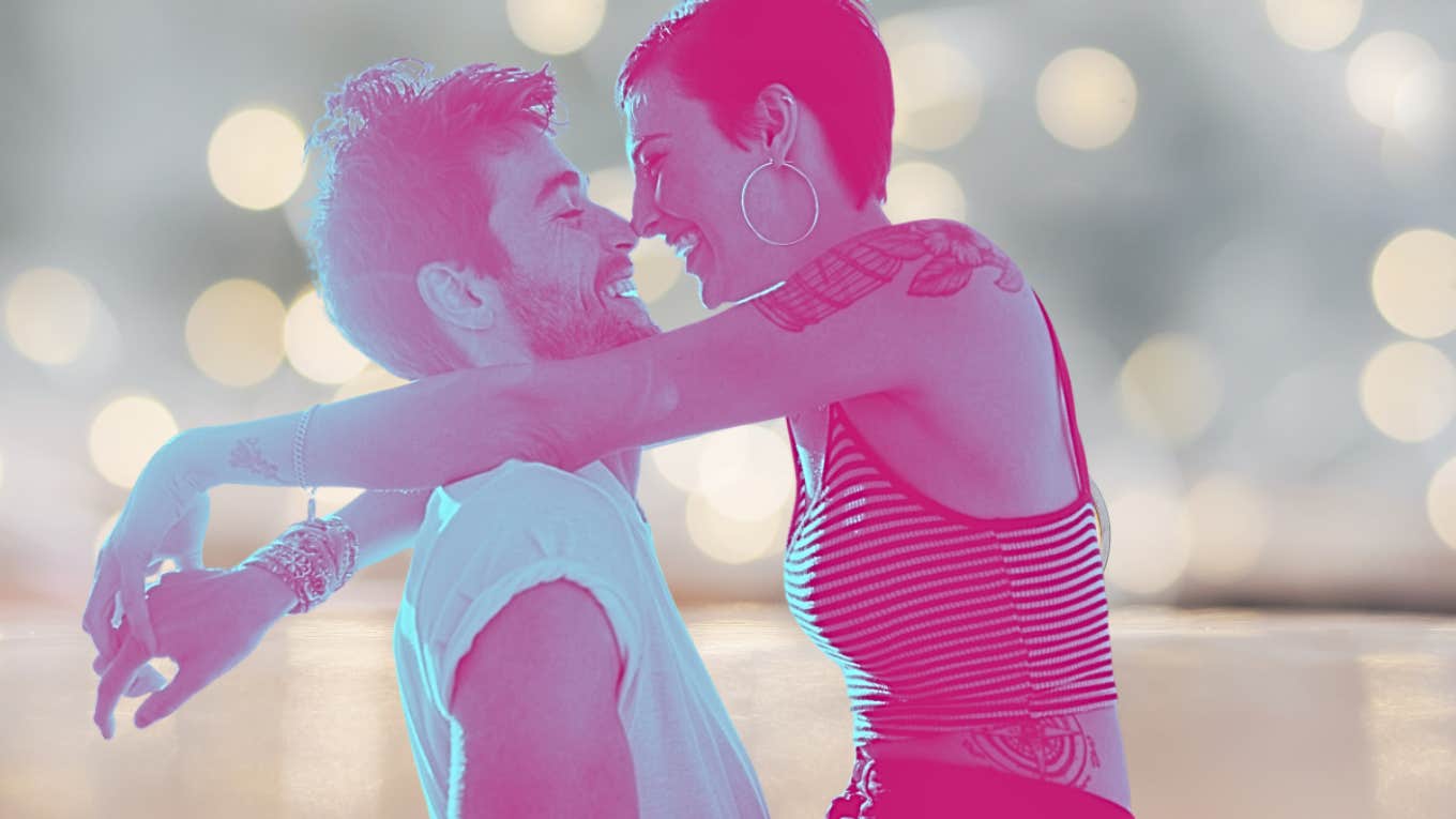 duo tone couple cuddling in front of a twinkle light background