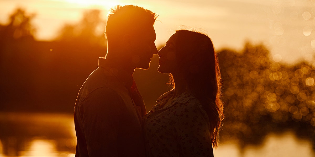 How He Physically Says I Love You, Based On His Zodiac Sign man and woman hugging at sunset