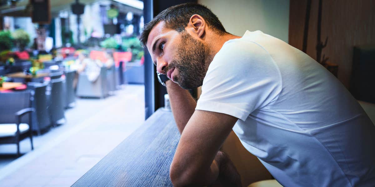 How Long It Takes A Guy To Regret Breaking Up man looking out of a window regretting breaking up