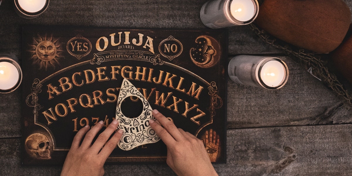hands over a ouija board planchette