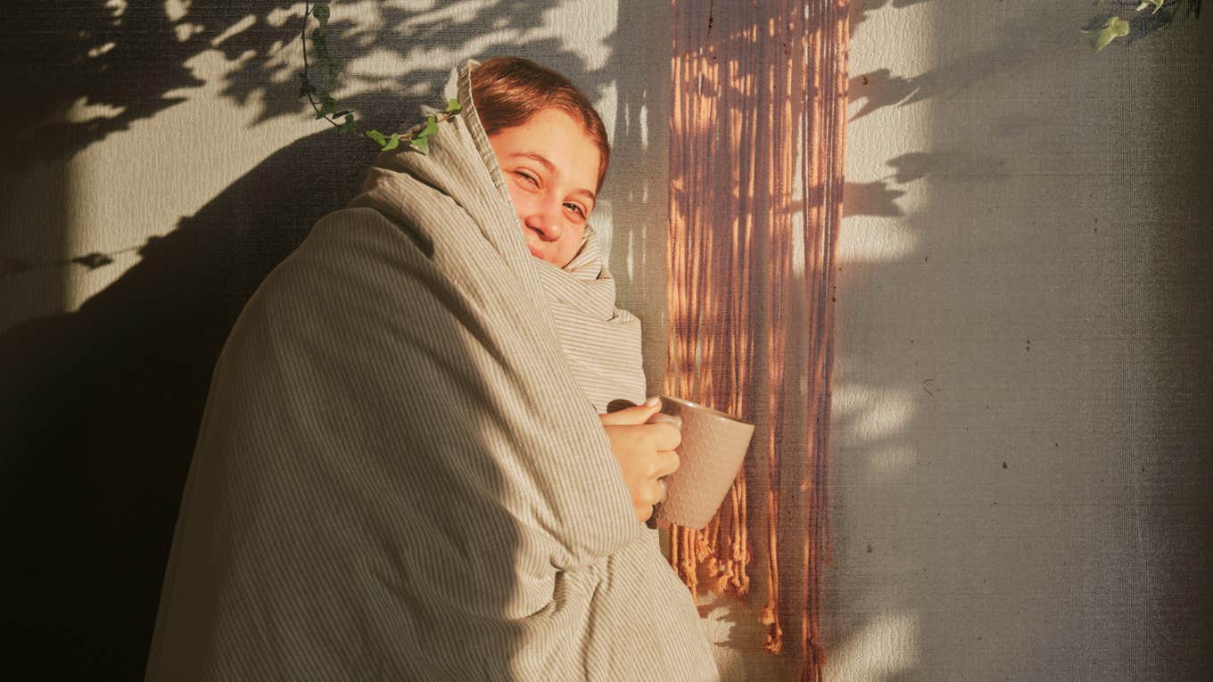 Woman snuggling in a comfortable blanket