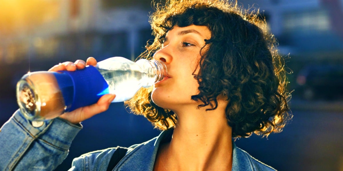 woman drinking from a bottle of water