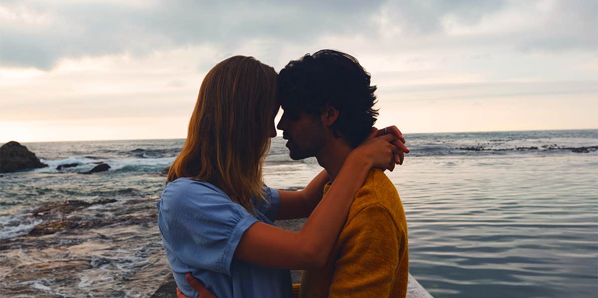 man and woman hugging on beach