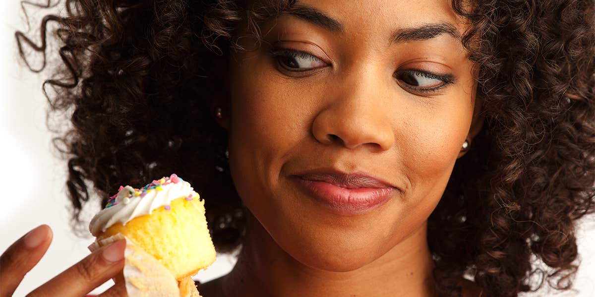 woman tempted to eat cupcake
