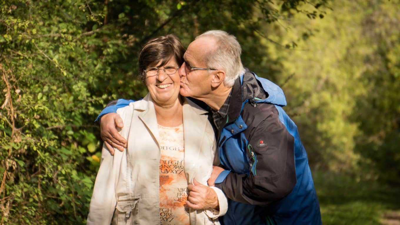 Old man kissing wife on the cheek 