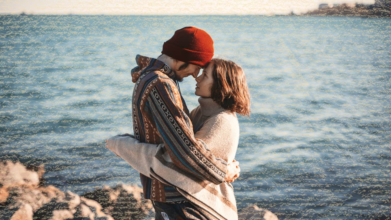 Couple foreheads together with the water behind them 