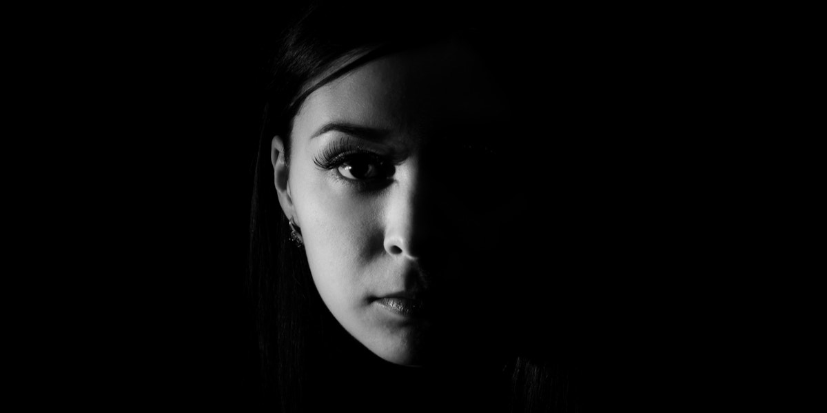 9 Ways To Access Your Dark Side & Heal Parts Of Yourself You Didn't Know Were Hurting woman in dark shadow