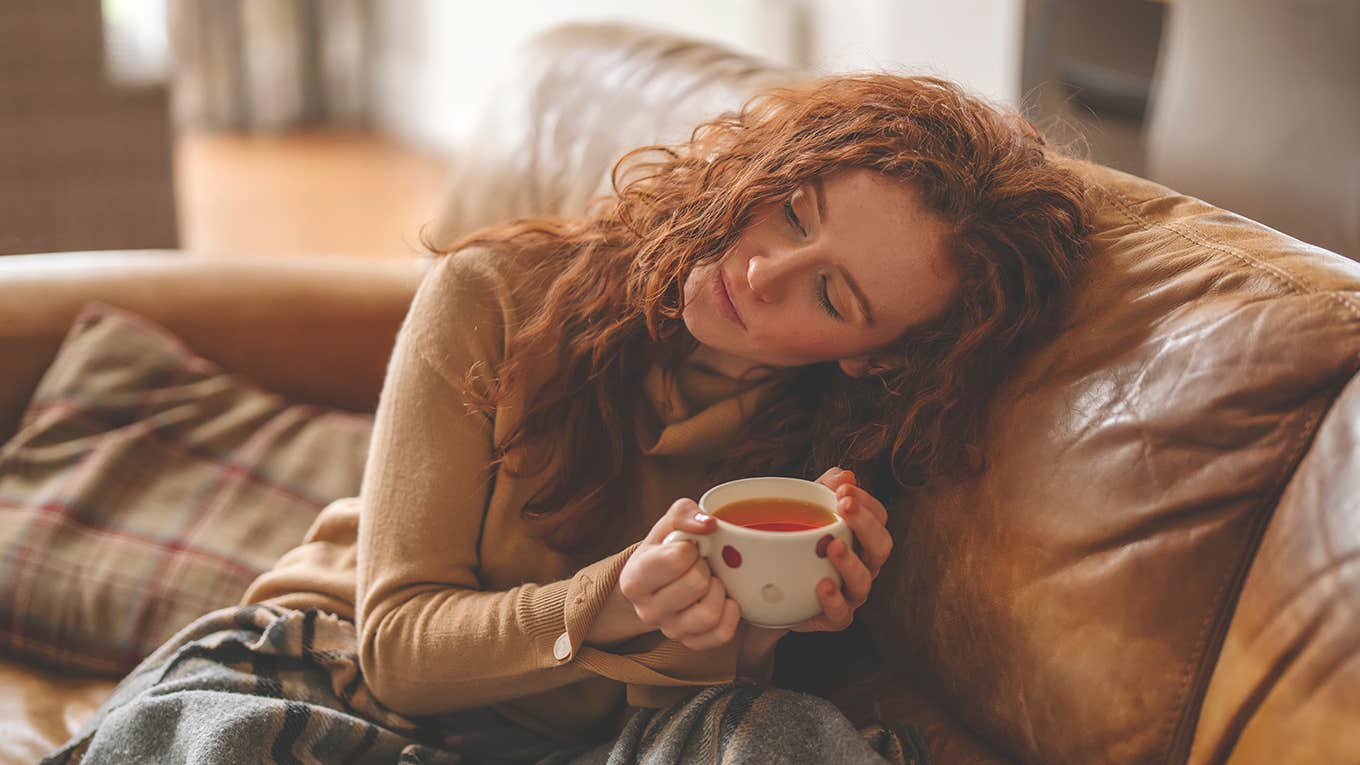girl sitting alone on couch drinking tea