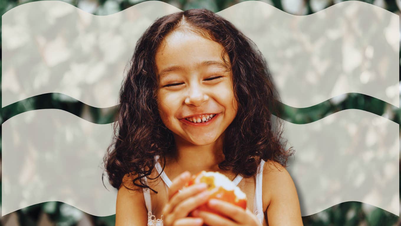 Happy young child eating an apple
