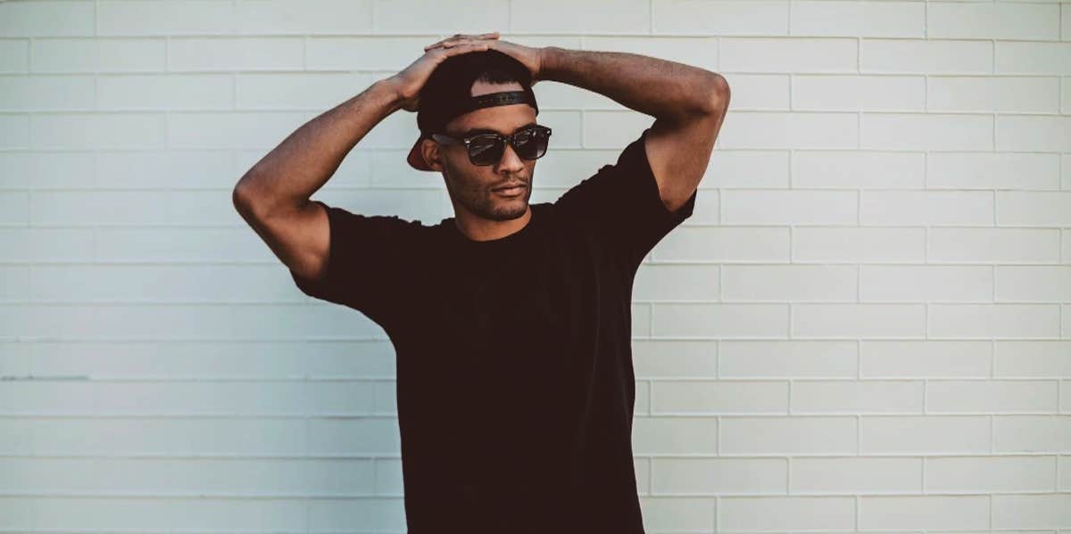 How To Tell A Guy Wants To Break Up With You guy standing alone with hat and sunglasses on