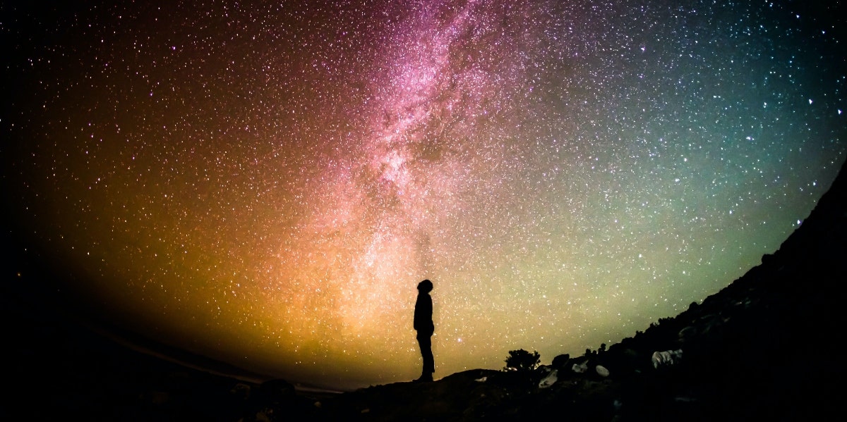 person looking up at the colorful sky