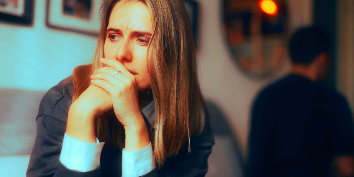 woman looking sad while man has his back turned