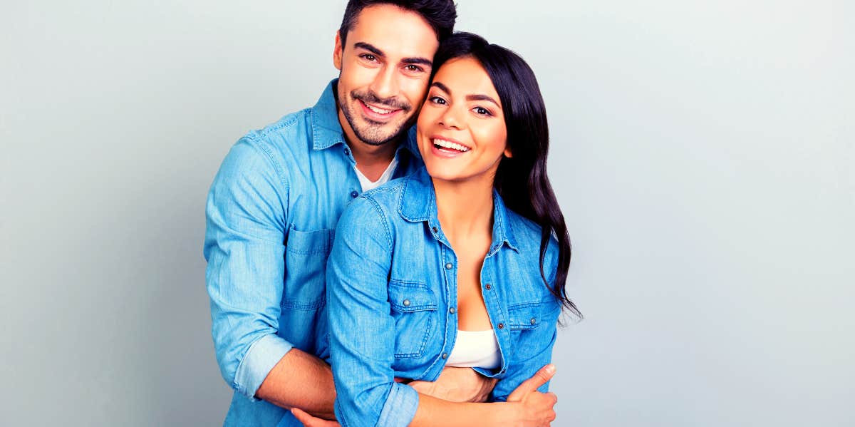 confident couple smiling while hugging and looking at camera