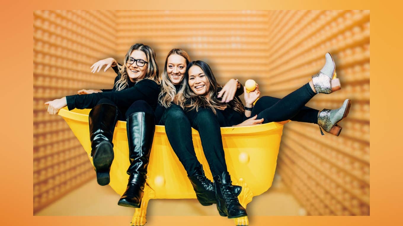 Friends laughing in a bright yellow bathtub