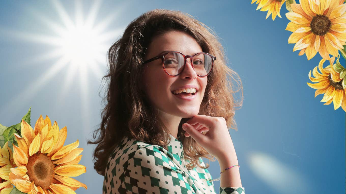 Woman smiling with sunshine in the background 