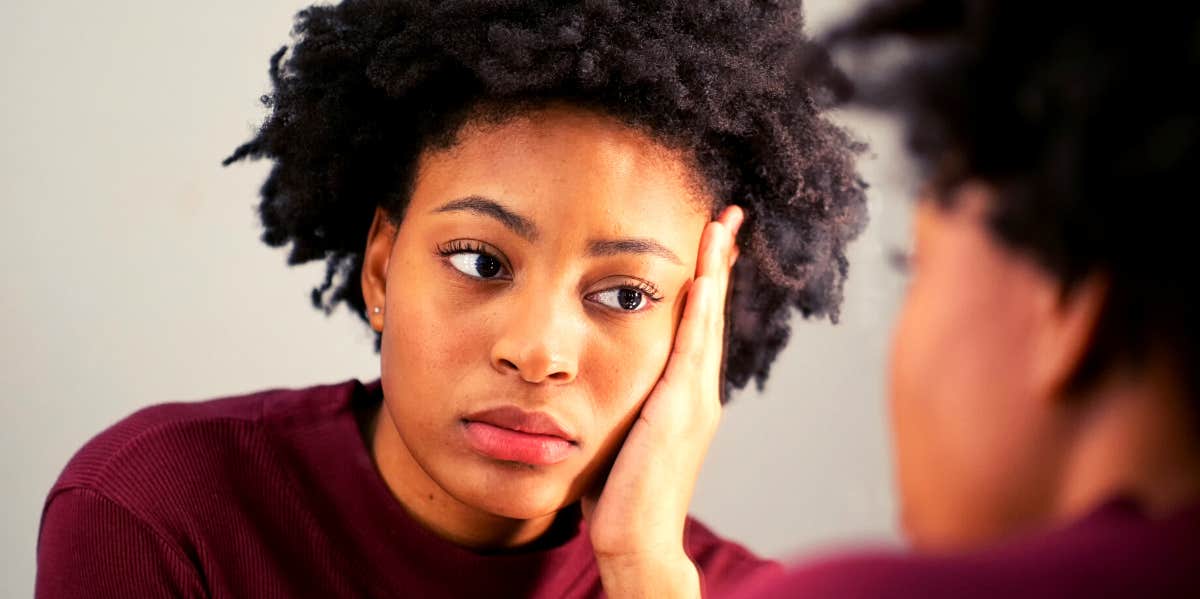 woman looking at herself trying to be honest with herself