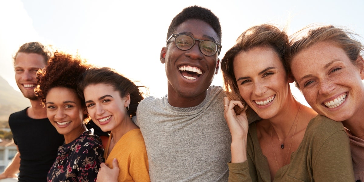 diverse group of people smiling with arms around each other