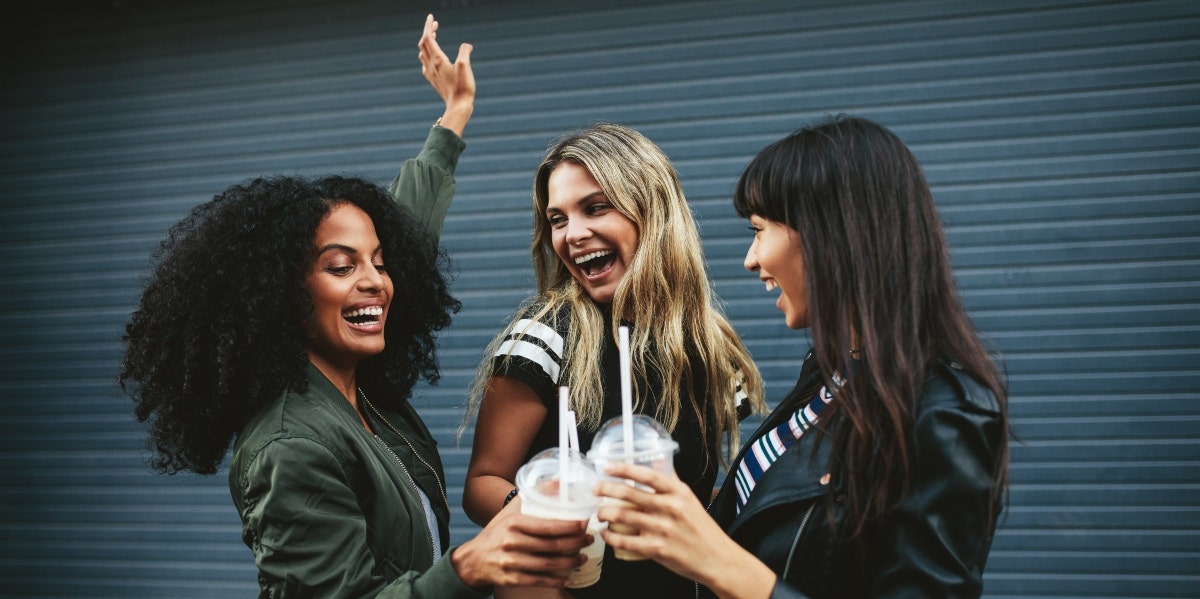 three female friends cheersing coffee