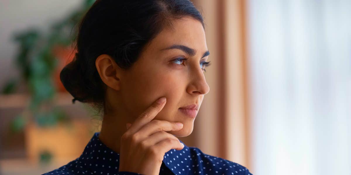 pensive woman looking out the window