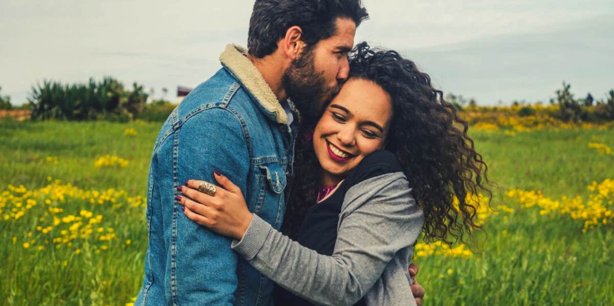 happy couple hugging in a sunny field