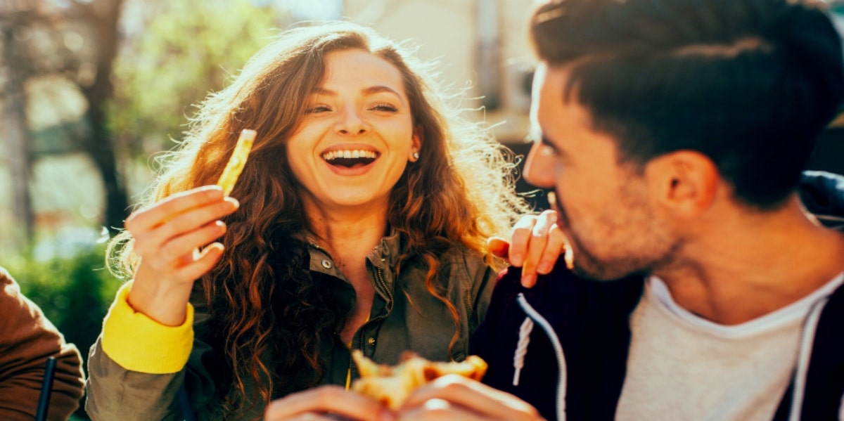 man and woman eating and flirting