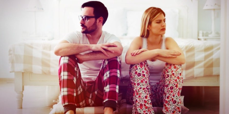 angry husband and wife sitting on floor