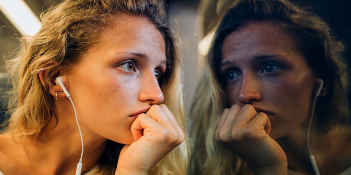 woman looking out window at her reflection