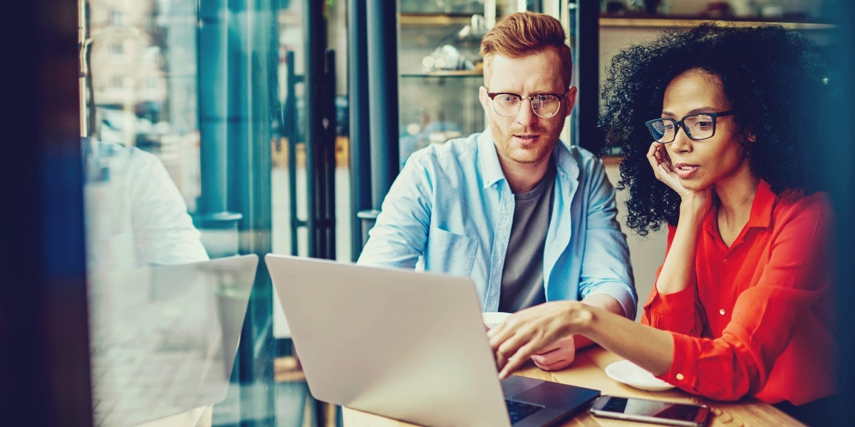 woman showing something on a computer to man