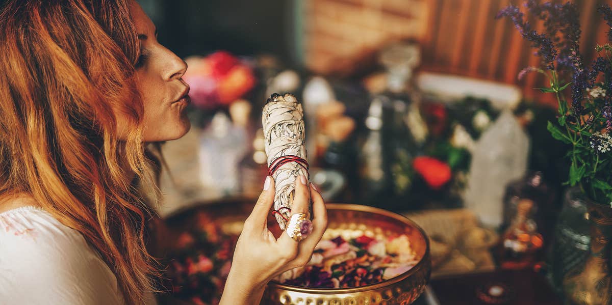 How To Do A Spiritual Cleansing & Remove Negative Energy From Your Life woman smudging