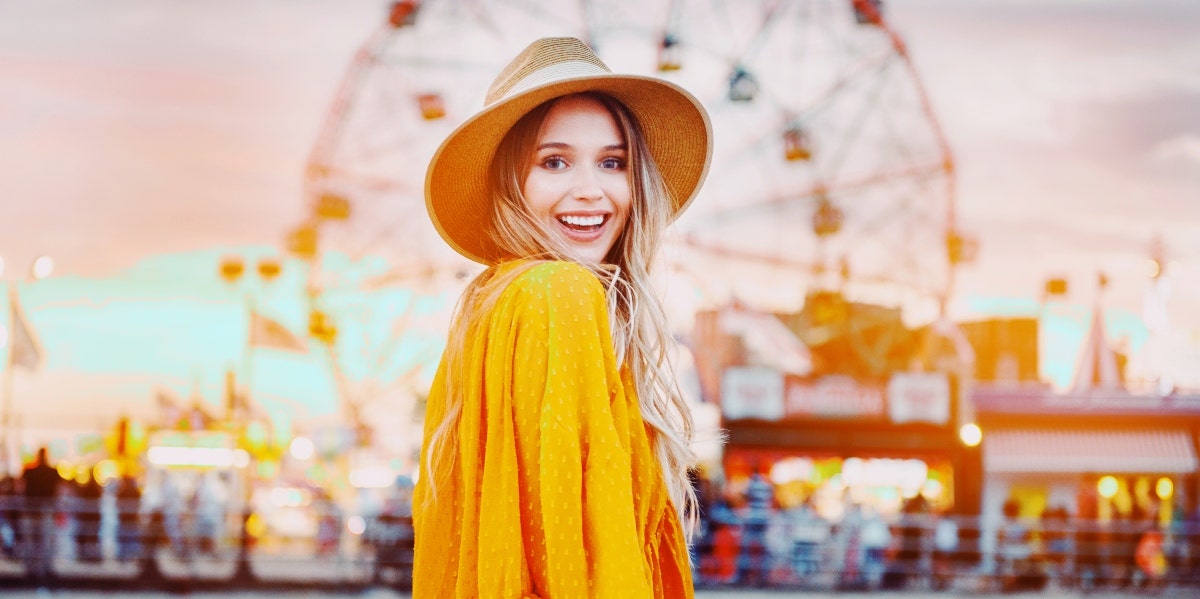 happy woman with a ferris wheel behind her