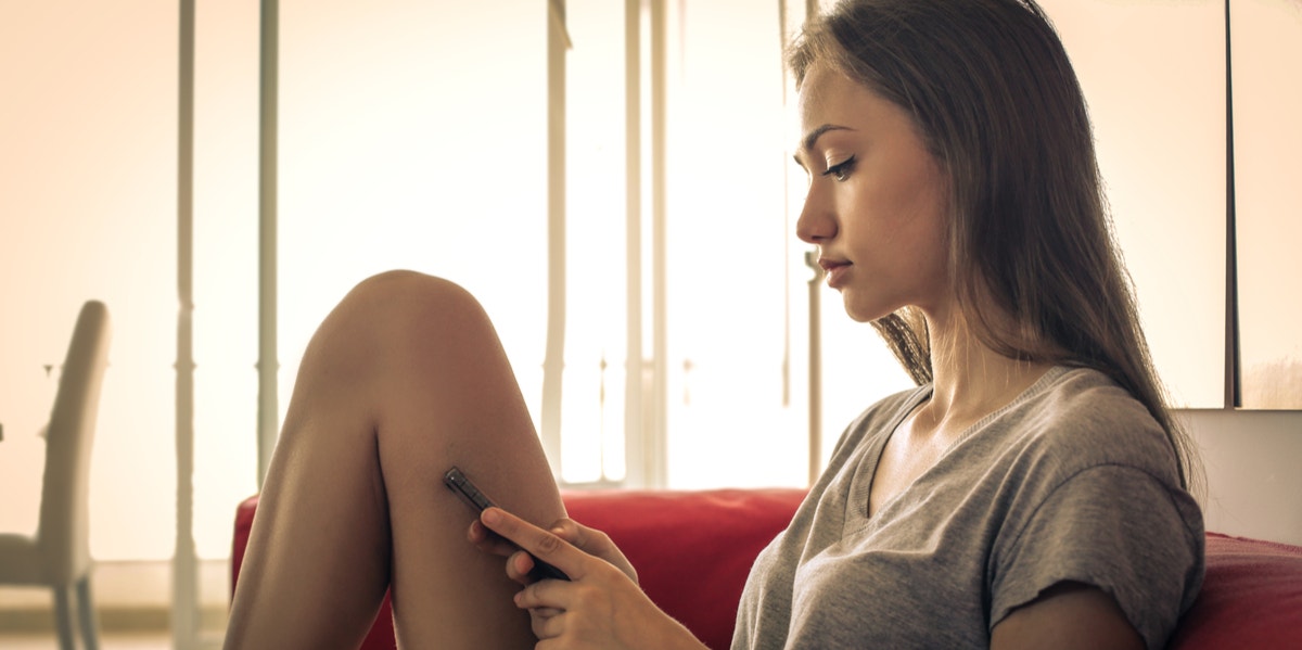 woman sitting on couch texting