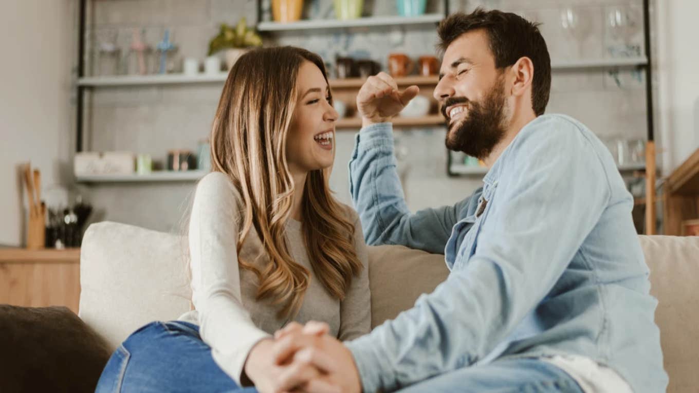 couple sitting on couch laughing and talking