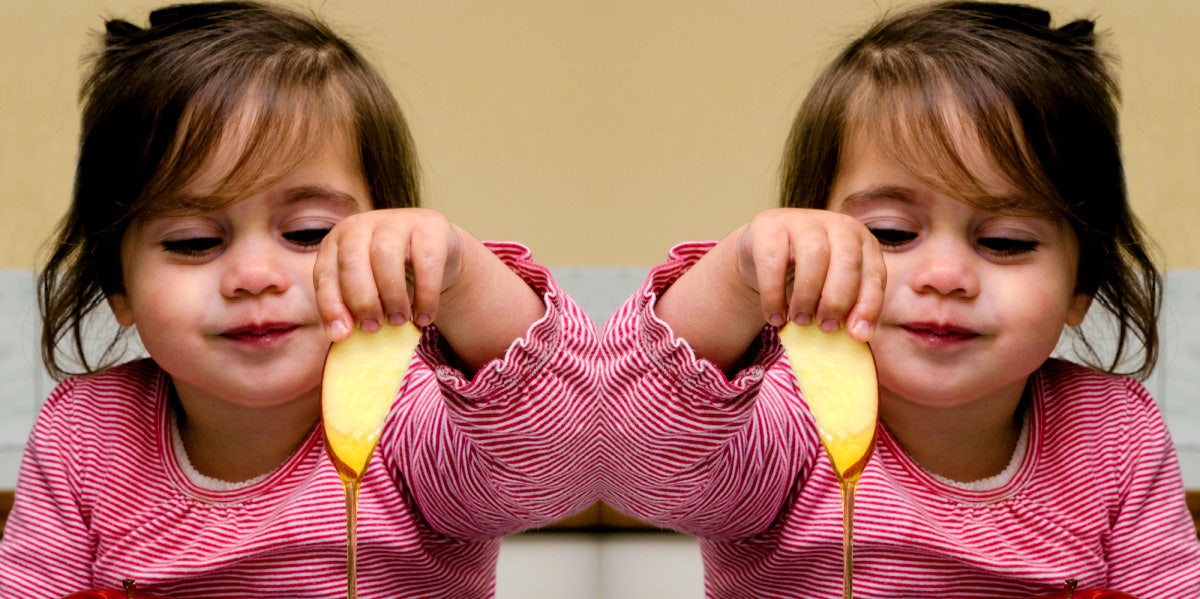 girl eating apples and honey on Rosh Hashanah