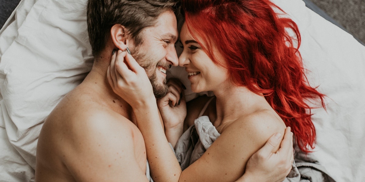 man and woman looking at each other in bed