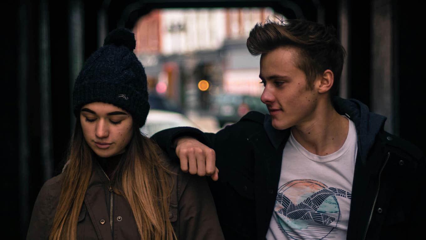 Man putting arm on woman's shoulder and the woman looking upset 