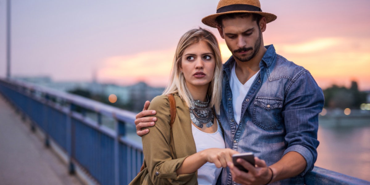 man looking on phone with woman