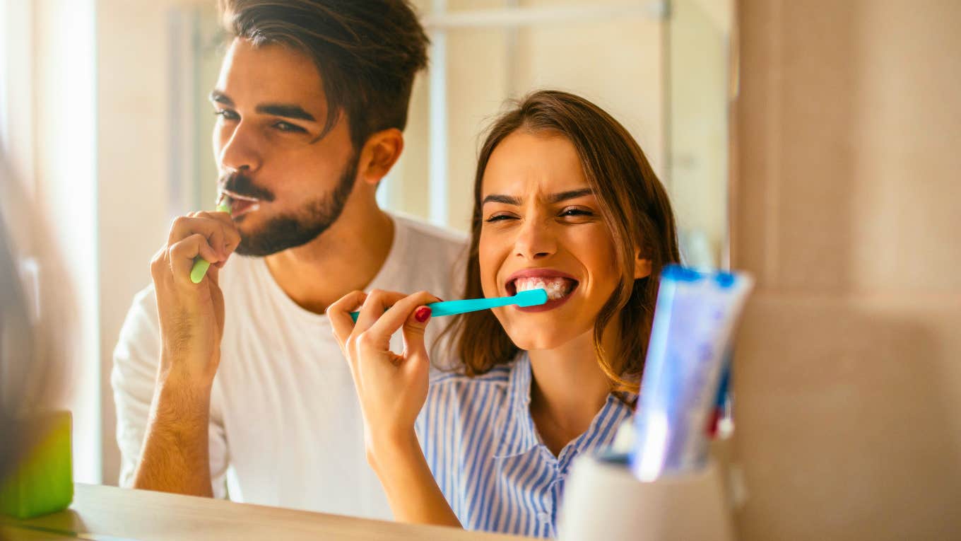 happy couple brushing their teeth