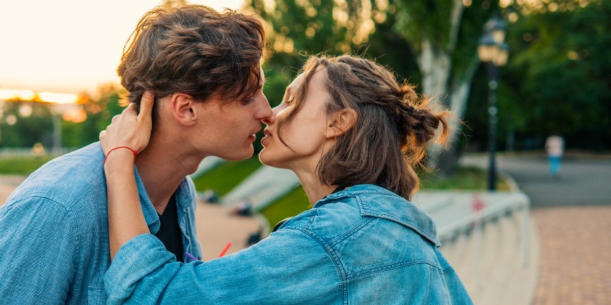 couple about to kiss woman's hand behind man's neck