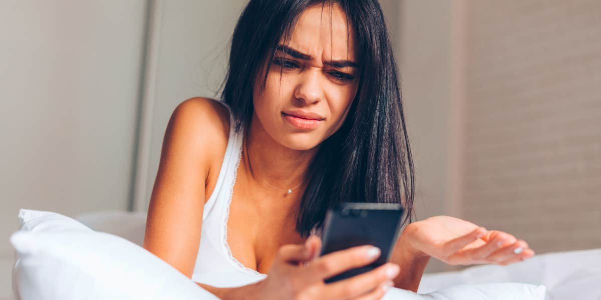 young woman looking at her phone wondering if someone blocked her