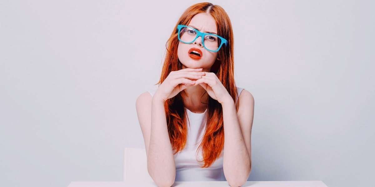 confused-looking woman in white in a white room 