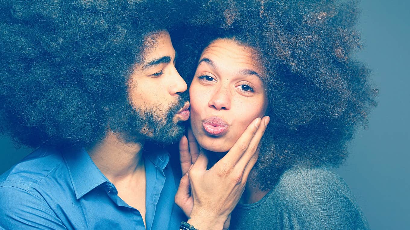 man kissing woman on the cheek