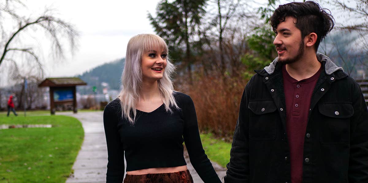 man and woman holding hands walking together