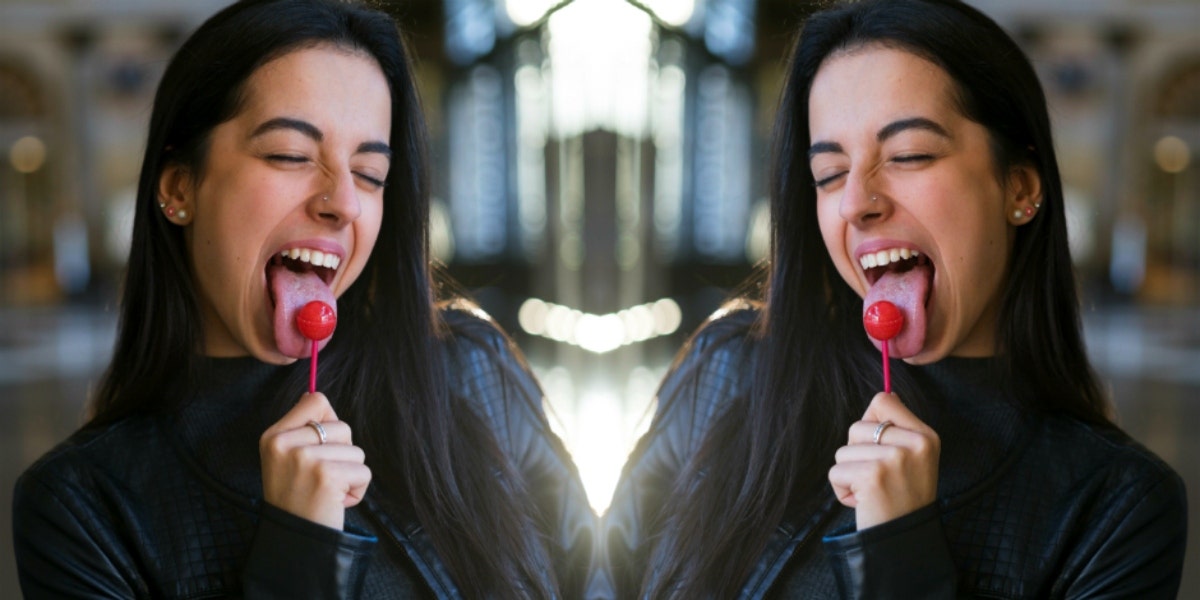 woman with tongue out licking lollipop