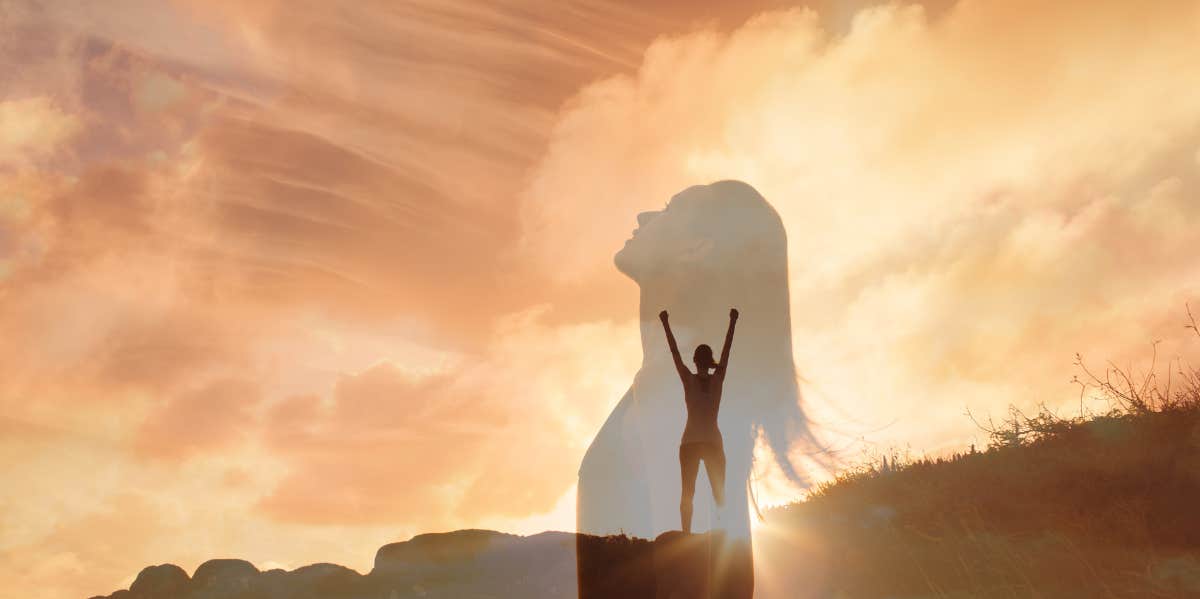 woman looking to sky and raising her arms