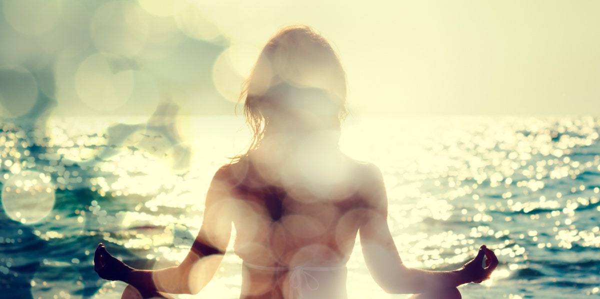 woman meditating by ocean