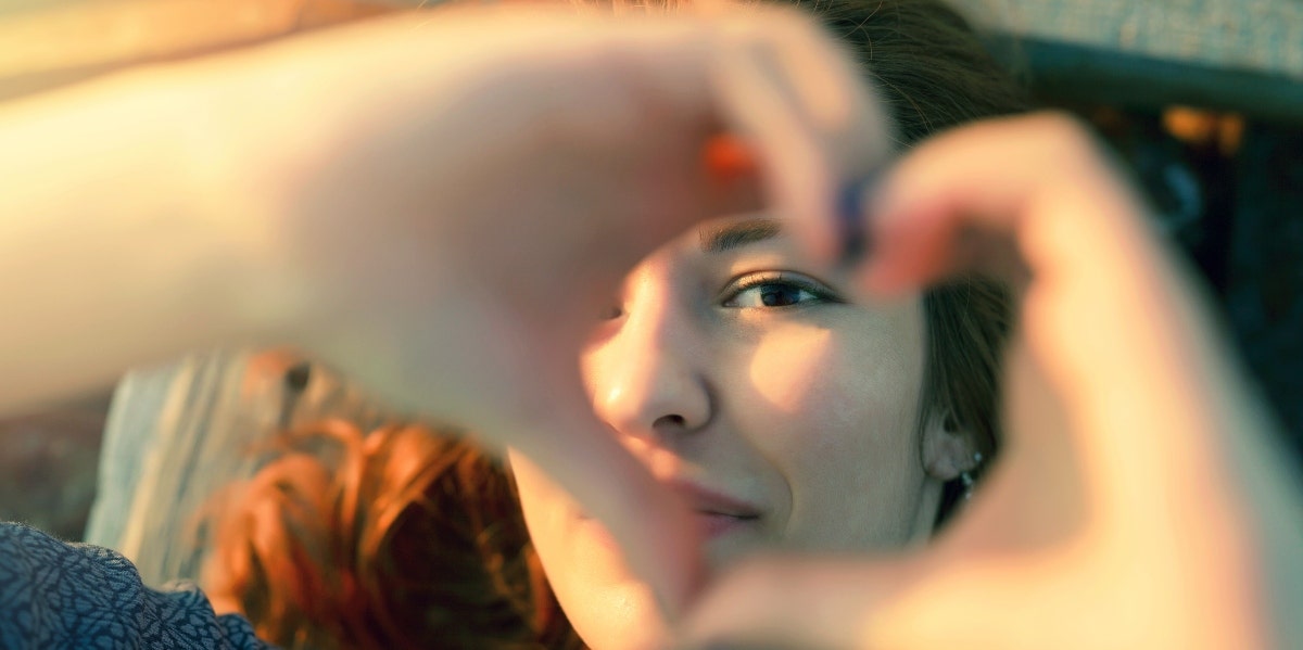 happy woman making heart shape with hands