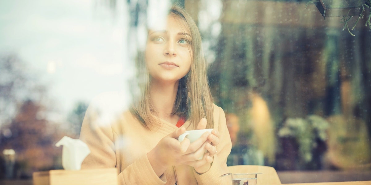 woman drinking tea looking out window