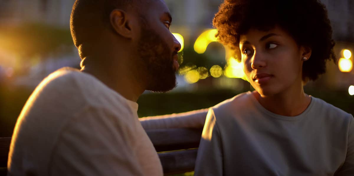couple looking into each other's eyes with hopeful facial expressions
