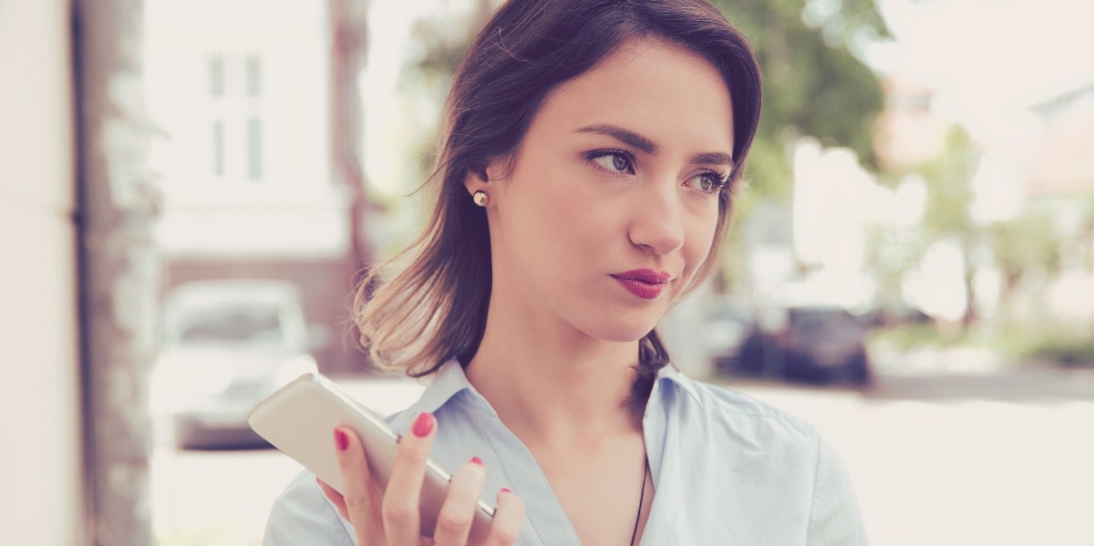 displeased-looking woman holding smartphone