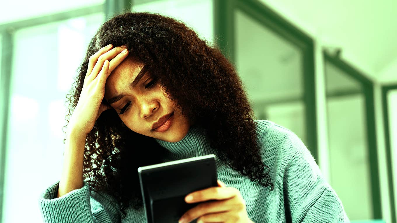 woman struggling with money holding wallet